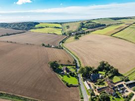 An aerial view of farmland with fields houses roads and trees at The Retreat Near Shorwell