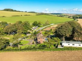 A countryside house with surrounding trees near fields and a road at The Retreat Near Shorwell