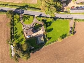 An aerial view of a house with surrounding lawns gardens and a road at The Retreat Near Shorwell
