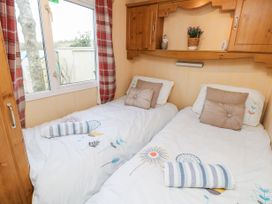A bedroom with two single beds with pillows and towels near a window at The Retreat Near Shorwell