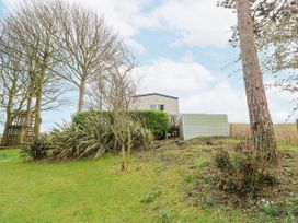 A small house on a hill surrounded by trees and bushes at The Retreat Near Shorwell