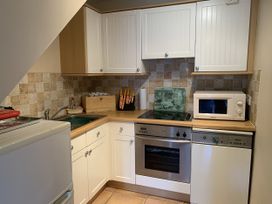 A kitchen with cabinets and appliances at Millers Cottage Seaville near Wigton