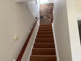 A staircase with carpet and a handrail at Millers Cottage Seaville near Wigton