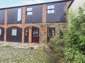 An outdoor view of a building with doors and windows at Millers Cottage Seaville near Wigton
