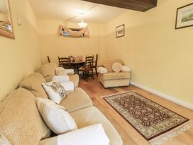 A living room with a sofa and dining table at Millers Cottage in Seaville near Wigton