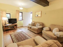 A living room with a sofa and television at Millers Cottage in Seaville near Wigton