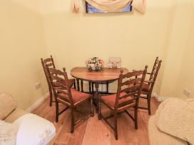 A dining area with a table and four chairs at Millers Cottage Seaville near Wigton