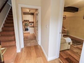 A hallway with stairs leading to the kitchen at Millers Cottage in Seaville near Wigton