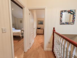 A corridor leading to a bedroom and staircase at Millers Cottage in Seaville near Wigton