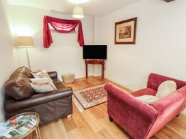A living room with a sofa and a television at Millers Cottage Seaville near Wigton
