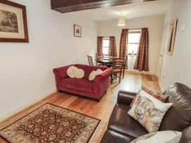 A living room with a sofa and dining table at Millers Cottage in Seaville near Wigton