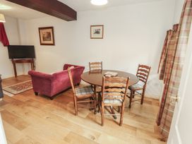 A dining room with a table and chairs at Millers Cottage in Seaville near Wigton