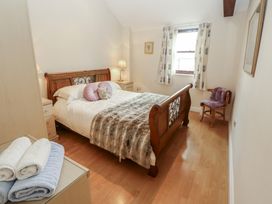 A bedroom with a bed and nightstand at Millers Cottage Seaville near Wigton