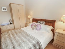 A bedroom with a bed and wardrobe at Millers Cottage Seaville near Wigton