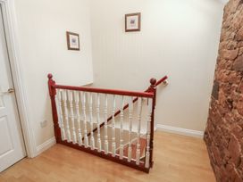 A stairway with wooden railing at Millers Cottage in Seaville near Wigton