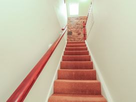 A staircase with carpet and window at Millers Cottage in Seaville near Wigton
