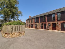 An outdoor view of buildings and trees at Millers Cottage in Seaville near Wigton