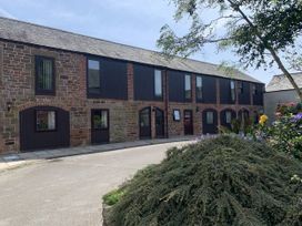 A building with multiple windows and a pathway at The Hayloft near Wigton