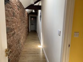 A corridor with a brick wall and wooden floor at The Hayloft near Wigton