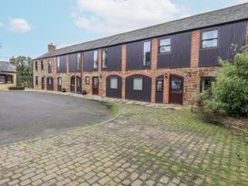 A building with windows and doors in a courtyard at The Hayloft near Wigton