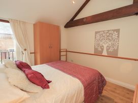 A bedroom with a bed and wardrobe at The Hayloft near Wigton
