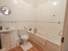 A bathroom with a bath tub, toilet, and sink at The Hayloft near Wigton