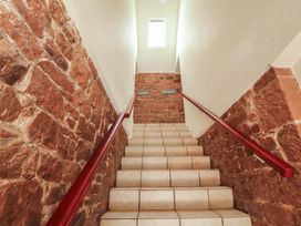 A staircase with stone walls and signage at The Hayloft near Wigton