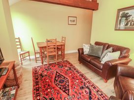 A living room with a table and chairs and a couch at The Hayloft near Wigton
