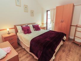 A bedroom with a bed and wardrobe at The Hayloft near Wigton