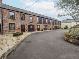 An outdoor view of a brick building with windows and pathway at The Coach House near Wigton