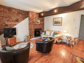 A living room with a television and a sofa at The Coach House near Wigton