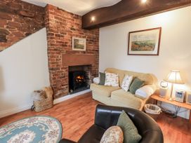 A living room with a sofa and a fireplace at The Coach House near Wigton