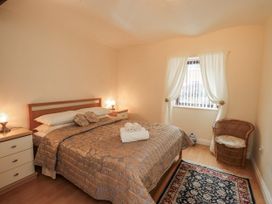 A bedroom with a bed and nightstands at The Coach House near Wigton