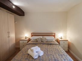 A bedroom with a bed, wardrobe, and nightstands at The Coach House near Wigton