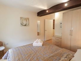 A bedroom with a bed and wardrobe at The Coach House near Wigton
