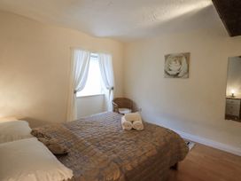 A bedroom with a bed and chair at The Coach House near Wigton