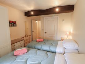 A bedroom with two beds and a lamp at The Coach House near Wigton