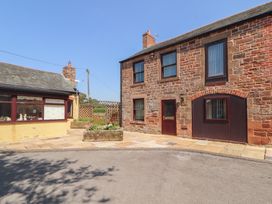 An exterior view of a brick building with windows and a door at The Coach House near Wigton