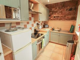 A kitchen with appliances and wooden cabinetry at The Coach House near Wigton