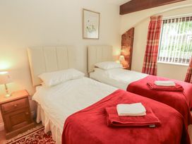 A bedroom with twin beds and a bedside table at The Coach House near Wigton