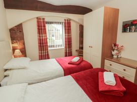 A bedroom with twin beds and a wardrobe at The Coach House near Wigton