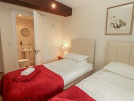 A bedroom with two beds and an ensuite bathroom at The Coach House near Wigton