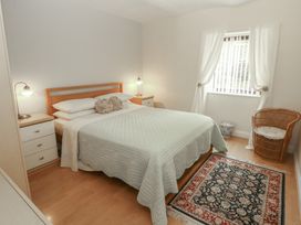 A bedroom with a bed, dresser, and window at The Coach House near Wigton