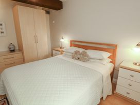 A bedroom with a bed and wardrobe at The Coach House near Wigton