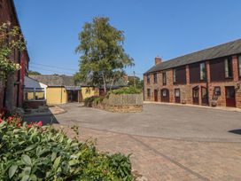 A courtyard with buildings and a tree at The Coach House near Wigton