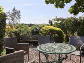 A garden with a table and chairs at Magnolia View Goodleigh near Barnstaple