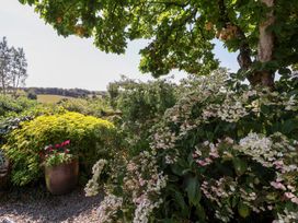 A garden with flowers and plants overlooking a landscape at Magnolia View Goodleigh near Barnstaple