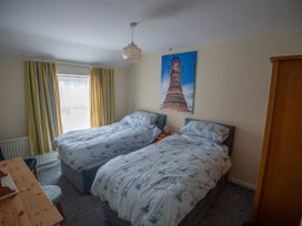 A bedroom with two beds and a window at 5 Bed Cottage Mumbles
