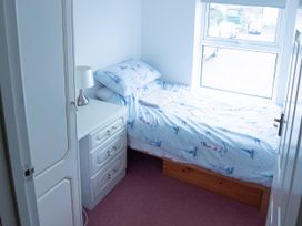 A bedroom with a bed and nightstand at 5 Bed Cottage Mumbles
