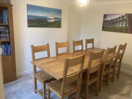 A dining room with a wooden table and chairs at Dunns Cottage in Mumbles